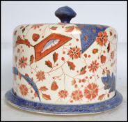 A large 19th century Staffordshire Imari pattern cheese dish and stand. The cover with finial