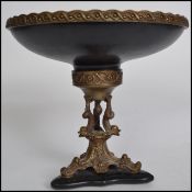 A 20th century bronze / brass tazza comport raised on a ceramic plinth base having rococo style