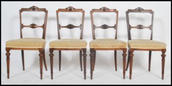A set of 4 Edwardian rosewood dining chairs being raised on turned fluted legs with overstuffed