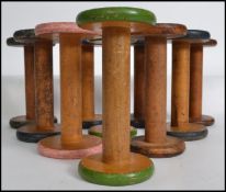 A group of 10 vintage multi colored painted cotton weaving wooden bobbins from a Lancashire mill,