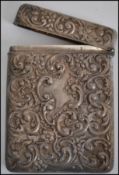 A silver hallmarked card / cigarette case of rococo form with central monogram cartouche panel.
