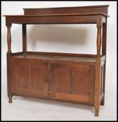 A Victorian oak buffet side table having twin door cabinet with raised shelf above on turned
