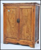 An early 20th century country oak and elm  school cupboard / side cabinet being raised on squared