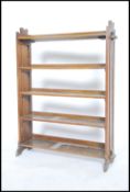 A Victorian oak Arts & Crafts peg jointed bookcase having twin slatted sides united by central row