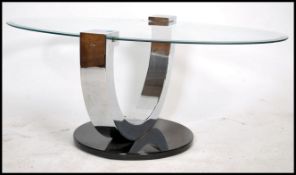 A 20th century modernist coffee table having a lozenge shaped bevelled glass table top over arched