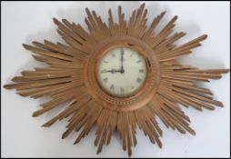 A retro 20th century Metamec starburst / sunburst wall clock of wooden construction with circular