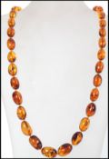 A vintage amber necklace of bead form, graduating in size on knotted string. Measures 60cms