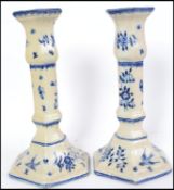 A pair of believed 19th century Delft blue and white candlesticks having bird and foliate