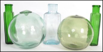 A group of vintage glass wares to include tow green glass fishing buoys with pontil marks and
