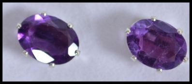 A pair of silver and amethyst ladies stud earrings on claw mounts with posts, complete in the