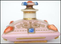 A 19th century Continental ceramic perfume bottle with fitted stopper. In the form of a bejewelled