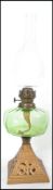 A Victorian gilt metal and green glass reservoir oil lamp complete with the glass flue