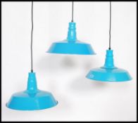 A set of three contemporary retro vintage style enamel ceiling pendant light fixtures. Having a