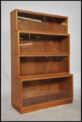 A mid century light mahogany 4 section stackling l