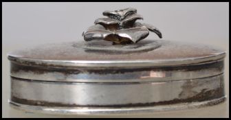 A silver hallmarked pill pox with silver rose atop having a hinged lid. Hallmarked for 2002