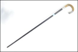 An early 20th century ebony walking stick cane having a shaped bone handle with hallmarked silver