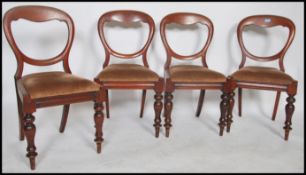 A Victorian mahogany set of 4 balloon back dining chairs raised on turned legs with overstuffed