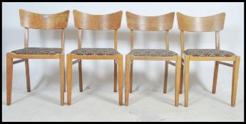 A set of four 1950's oak original Ernest Gomme butterfly oak wood dining chairs, padded drop in seat