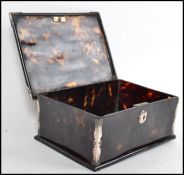 A silver and tortoiseshell table top cigarette box having hinged top with circular key escutcheon.
