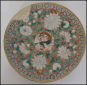 A Chinese famille rose wall charger having red ground with central dragon surrounded by foliate