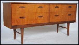 A 1970's retro Danish influence teak wood sideboard raised on tapered legs with a series of 4