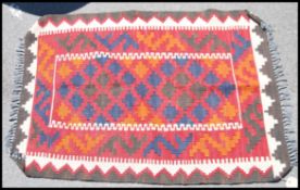 A large and colourful Afghan handwoven  Maimana Kilim rug having red ground with diamond lozenge