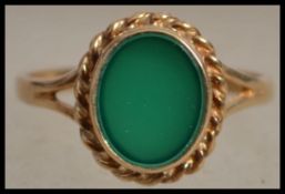 A hallmarked 9ct gold ring set with an opaque gree