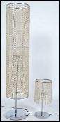 A contemporary floor standing chrome lamp of tall form having many strands of droplets along with