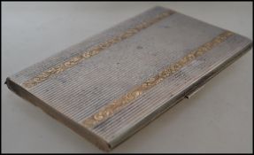 A continental silver 800 machined cigarette case having applied overlay gilt decoration