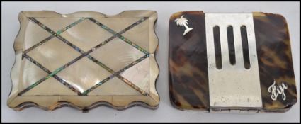 A mother of pearl opening purse having a sloped edged design along with a tortoise shell card case