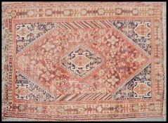 A vintage fine quality handmade tribal carpet rug on a rust background having alternating