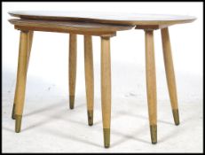A retro 1970's vintage pebble nest of tables, each table raised on turned tapering legs having