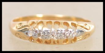 An early 20th century 18ct gold 5 stone diamond ring having a pierced gallery and scrolled