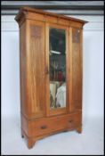 A good early 20th century Arts & Crafts oak single wardrobe having mirror door with panel sides over