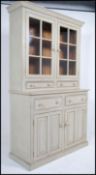 A 20th century antique cottage shabby chic style painted dresser having a glass cabinet with drawers