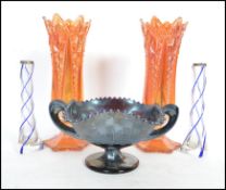 A pair of early 20th century orange lustre carnival glass vases together with a purple irridescent