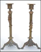 A pair of 19th century Art Nouveau brass candlesticks of column form raised or naturalistic tripod