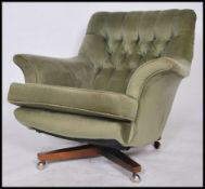 A good 1970's retro  egg shaped swivel armchair being raised on a 4 point teak wood swivel base