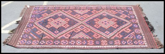 A large Afghan / Persian handwoven kilim rug of black and red ground with geometric patterns and