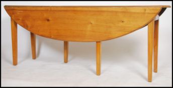 A large 20th century antique style cherry wood ' wake ' table of large form being raised on tapering