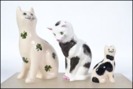 A group of three Wemyss ceramic cat figurines to include Compton and Wood house example and two G