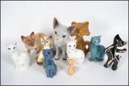 A collection of cat figurines to include a good Studio pottery cat Devon Rex signed BT together with