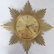 A 1950's retro starburst wall clock by Junghans Ato-Mat in brass with brass bursts and gilded face