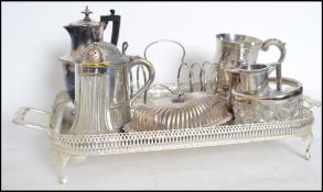 A collection of silver plated wares to include a large gallery tray, toast rack with glass dish to
