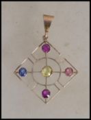 A 9ct gold Art Nouveau necklace pendant being set with coloured stones, possibly sapphires