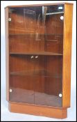 A retro 1970's teak wood corner cabinet having shelved interior with smoked glass panel door