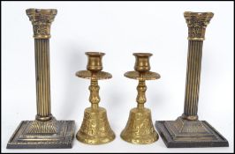 A pair of brass candlesticks in the neo classical style together with a pair of gilt metal bell