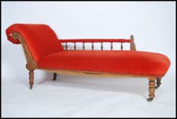 An Edwardian mahogany chaise longue day bed having turned legs with vibrant orange upholstered