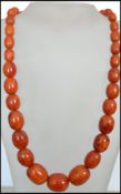 A mid century retro amberite ladies bead necklace of graduating form having a white metal screw