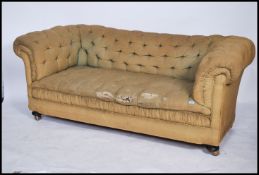 A good Victorian Chesterfield sofa raised on bun feet having a green fabric button backed seat and